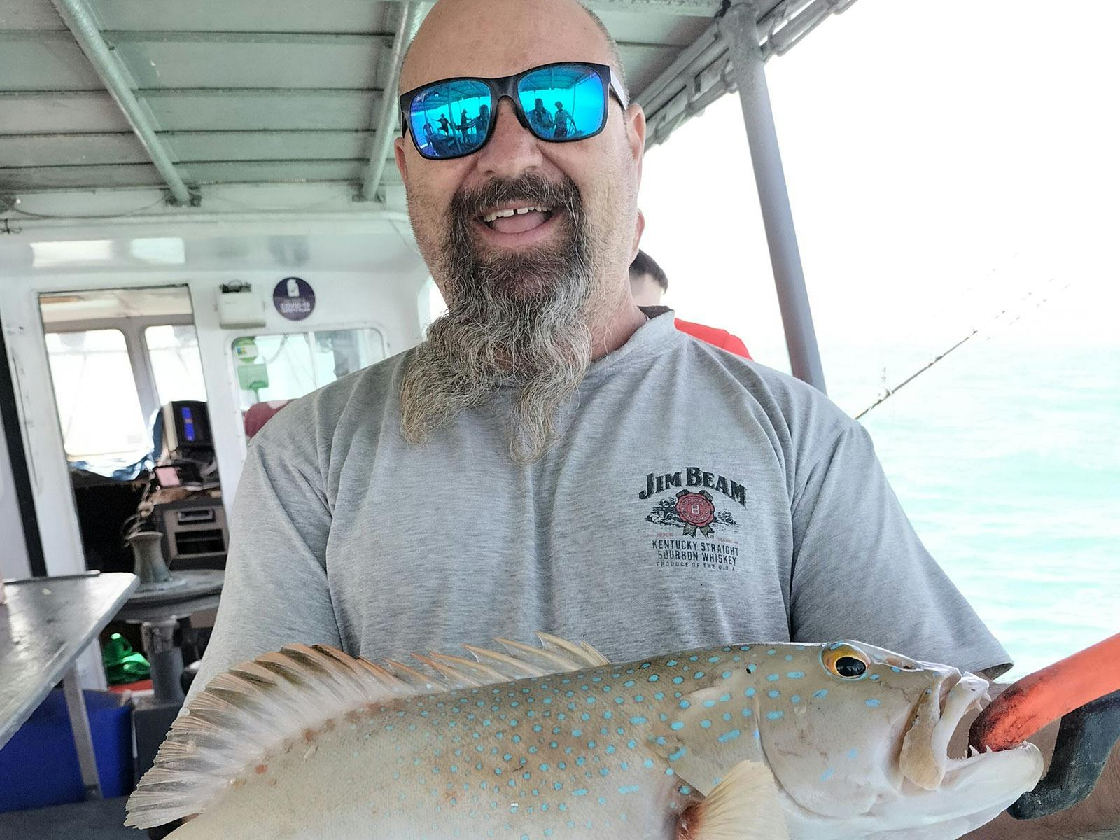 A man holding a fish on a Darwin Red Devil Charter.