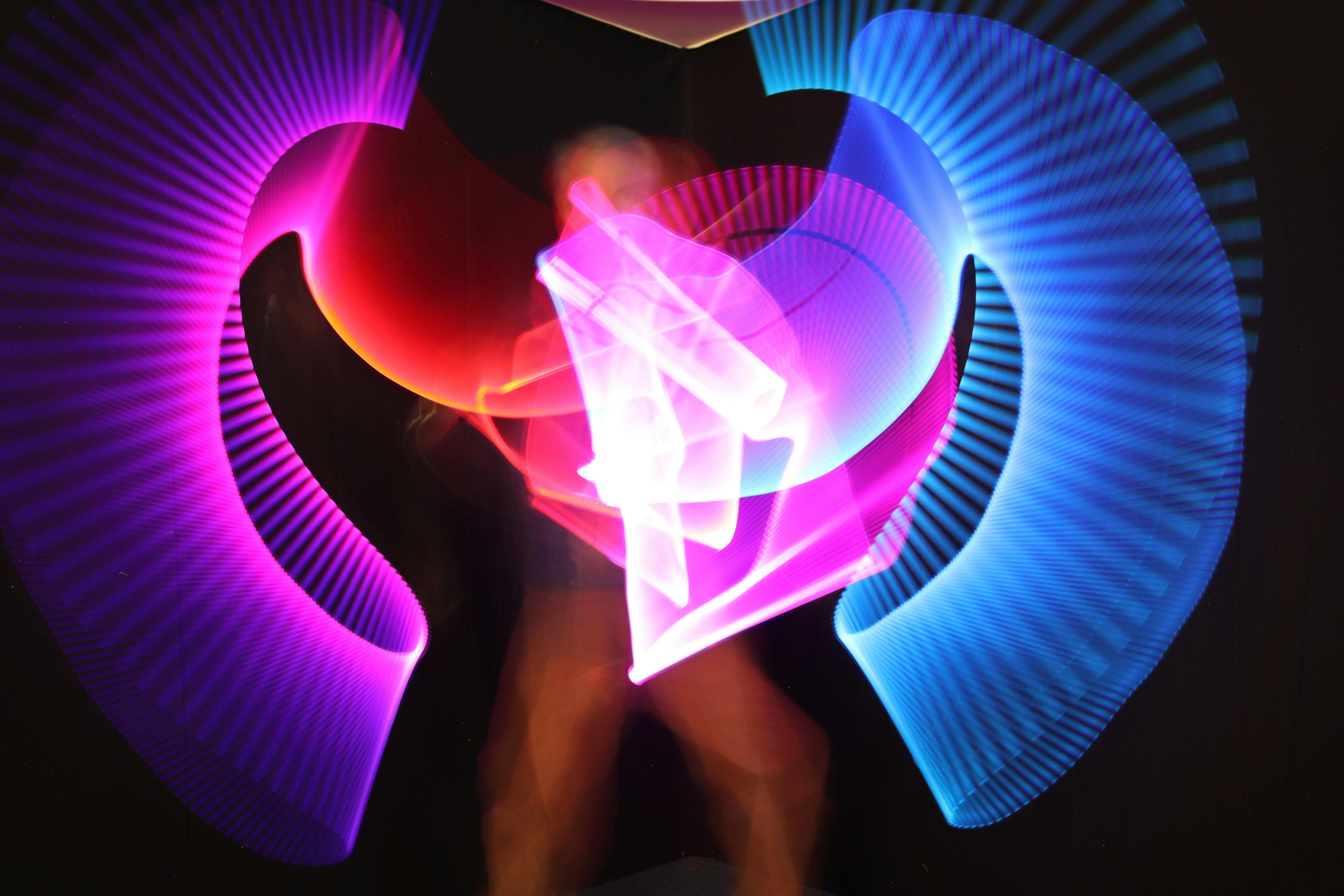 Bright patterns in blue, purple and red draw with light, captured by a photographer .