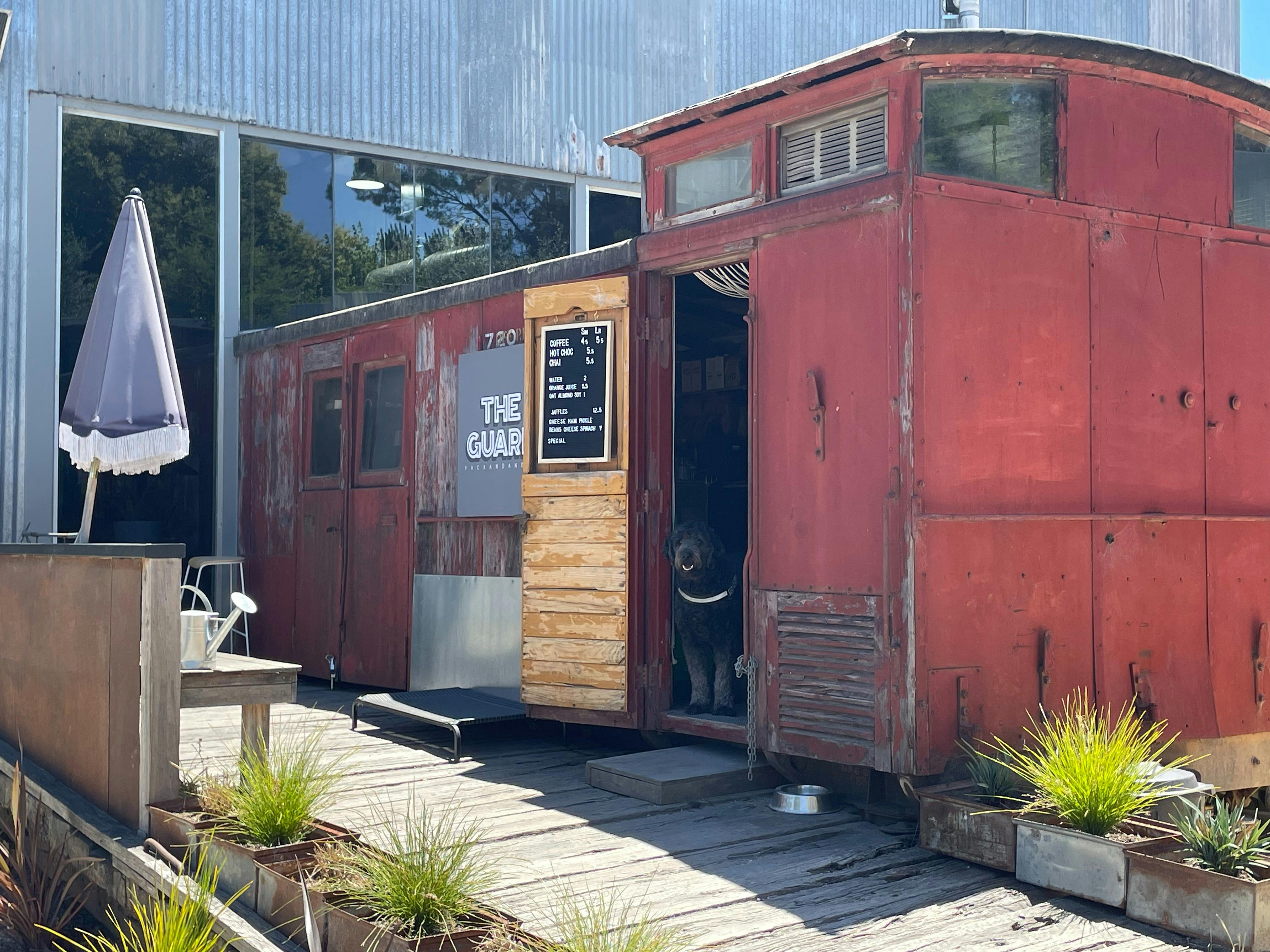 image shows a red train carriage with menu board and the door open.