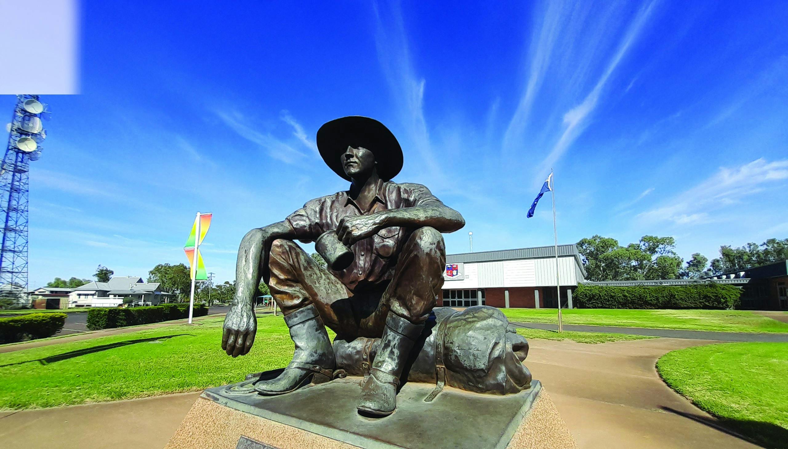 Large bronze statue of The Cunnamulla Fella, set against the backdrop of stunning blue skies
