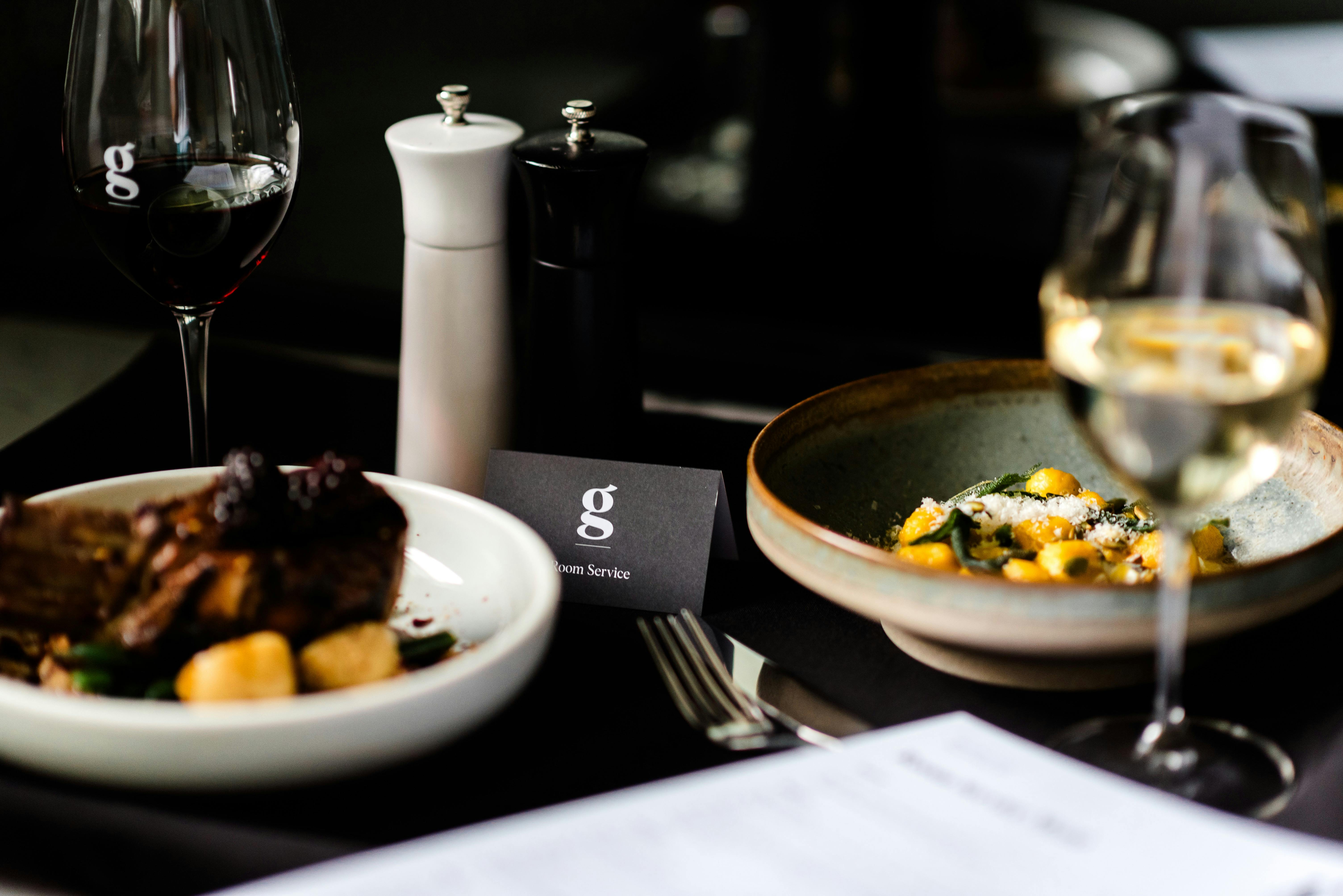 Room service is delivered offering lamb, gnocchi and wine from the hotel restaurant menu