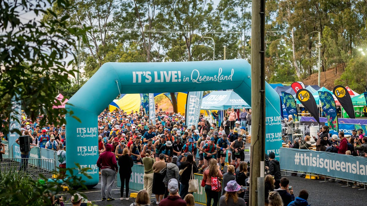 Runners starting the 50km event under the It's Live in Queensland arch
