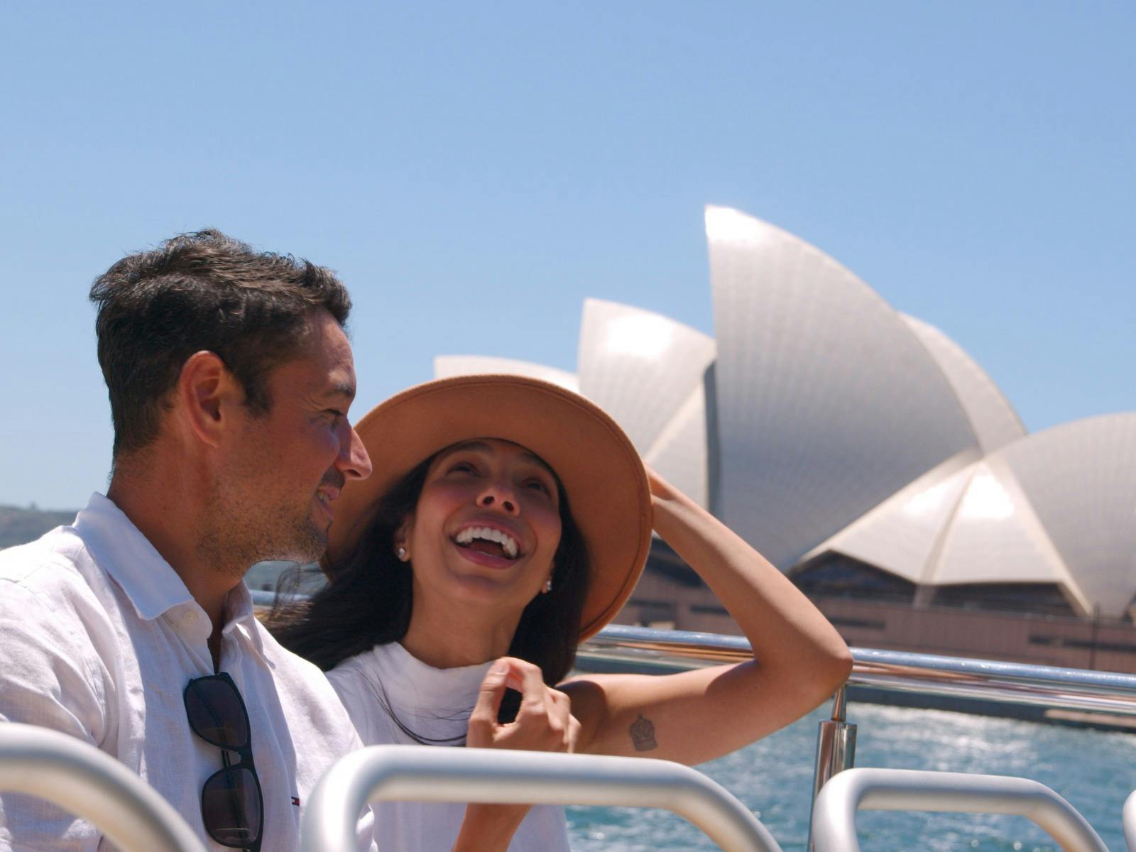 couple enjoying sightseeing cruise in front of Sydney Opera House