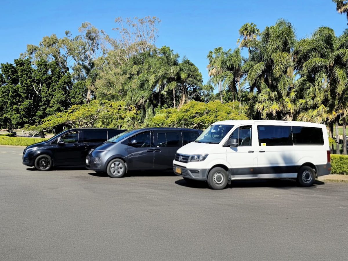 Mercedes, Hyundai, and Volkswagen vans from GEC Transfers parked in a row under a sunny sky