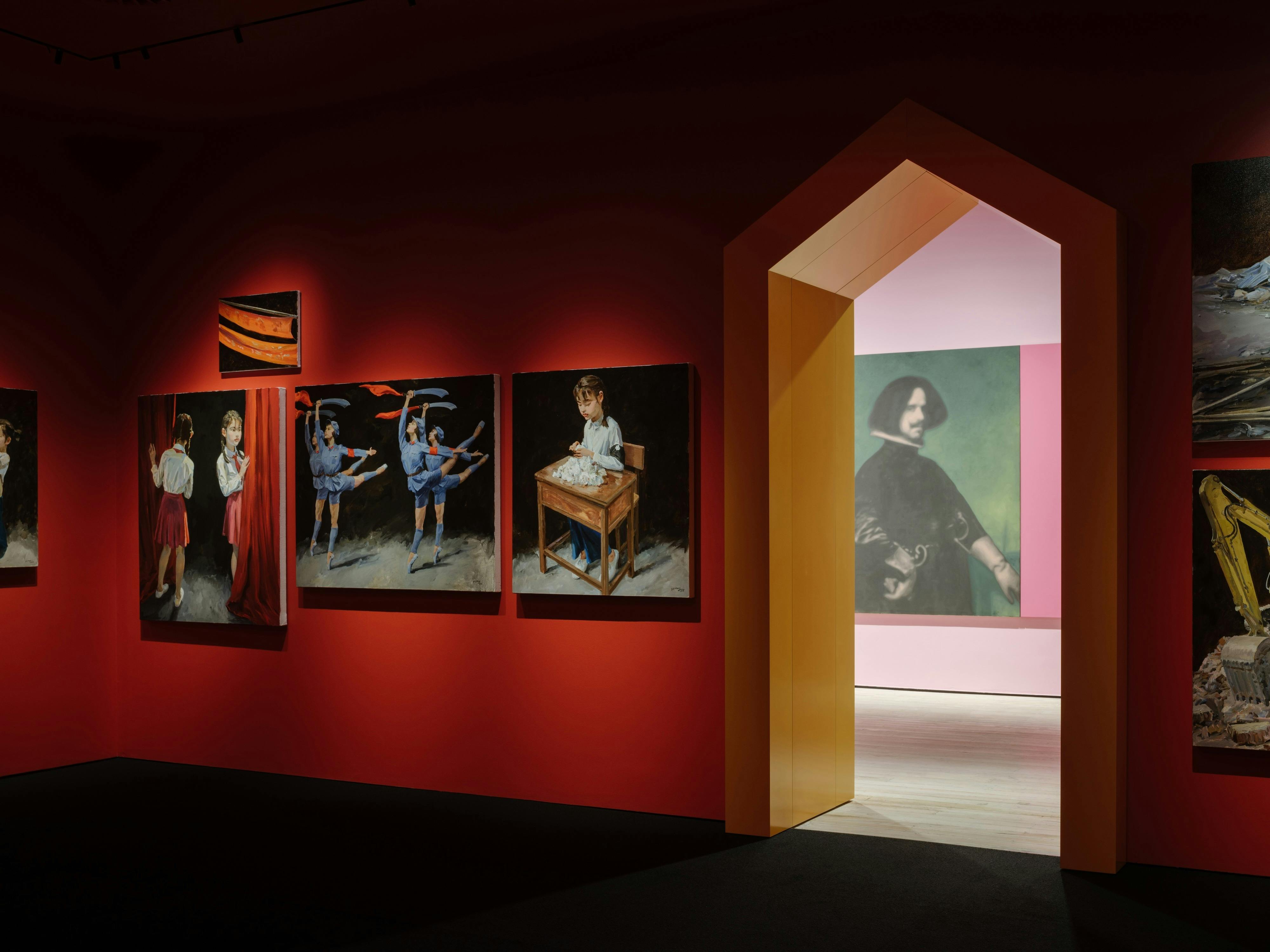 Red walled gallery room with Yu Hong paintings, with a view through a doorframe to another room