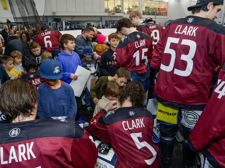 Ice hockey players sign autographs for fans of all ages