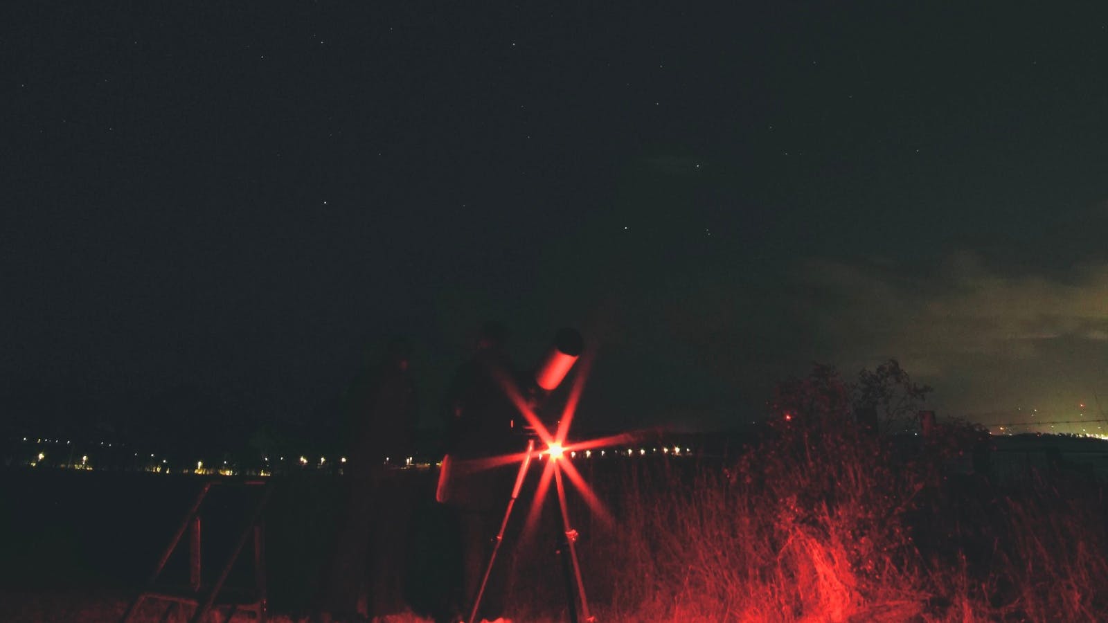 Telescope set up under the night sky with red tour lighting at Iron Creek Bay Estate.