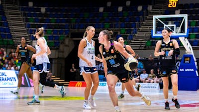 UC Capitals player driving to the basket for a layup during a WNBL game.