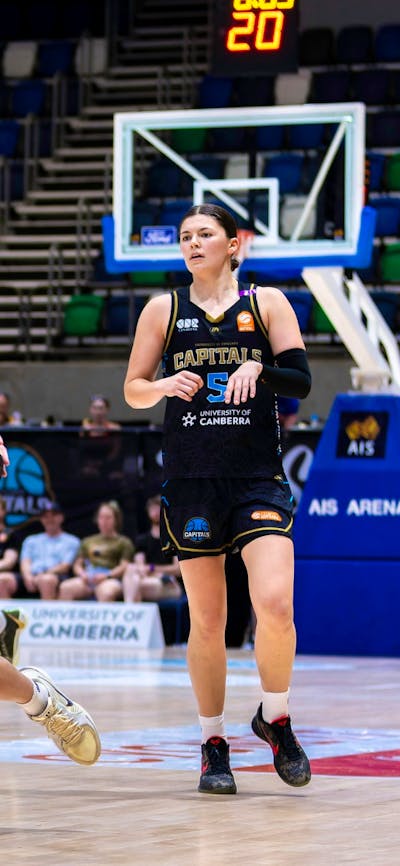 UC Capitals player driving to the basket for a layup during a WNBL game.