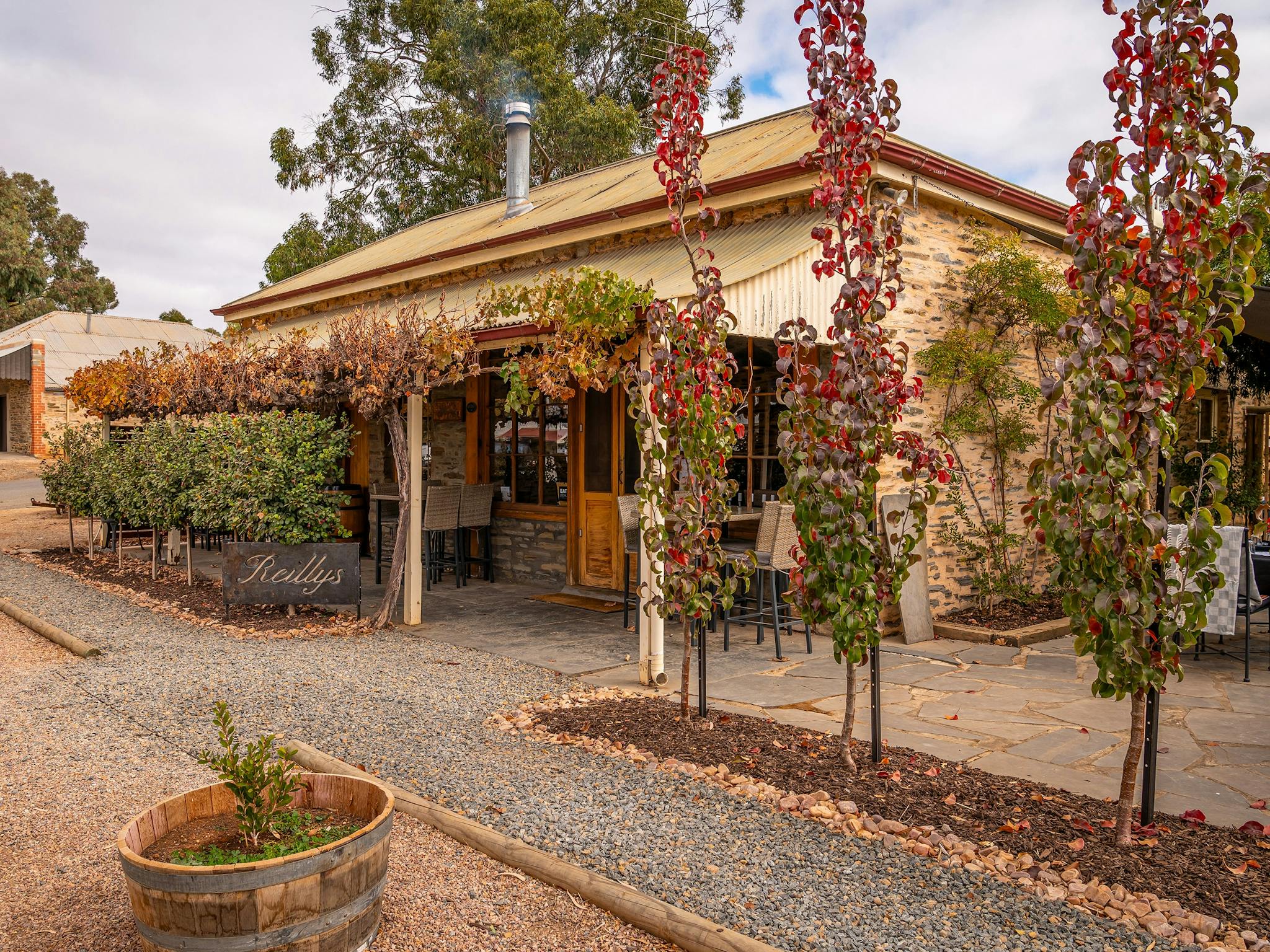 Front of Reillys Wines Cellar Door & Restaurant heritage building with autumn vines and bushes