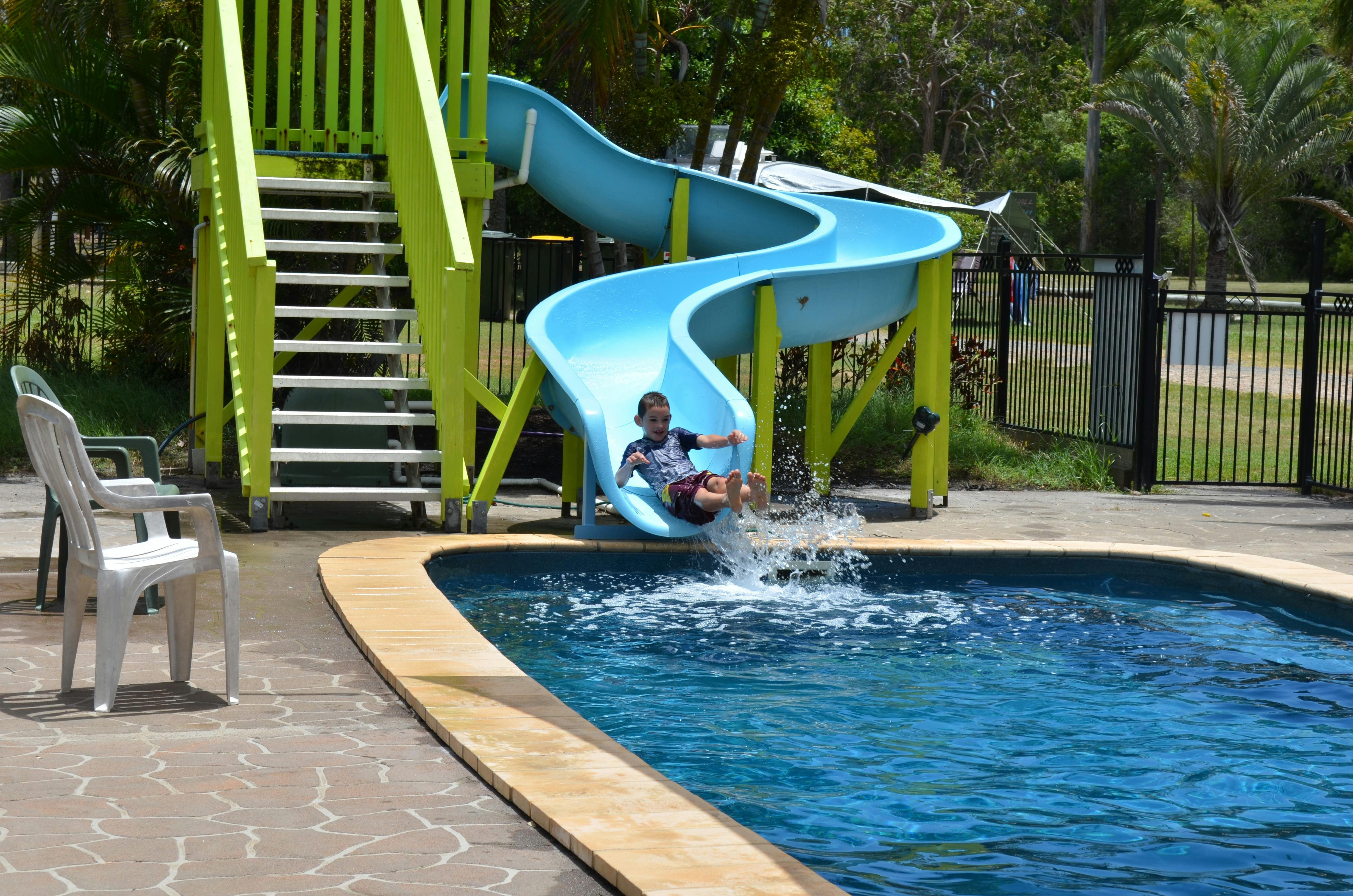 photo of boy sliding down wetslide into pool at Poona Palms Caravan Park