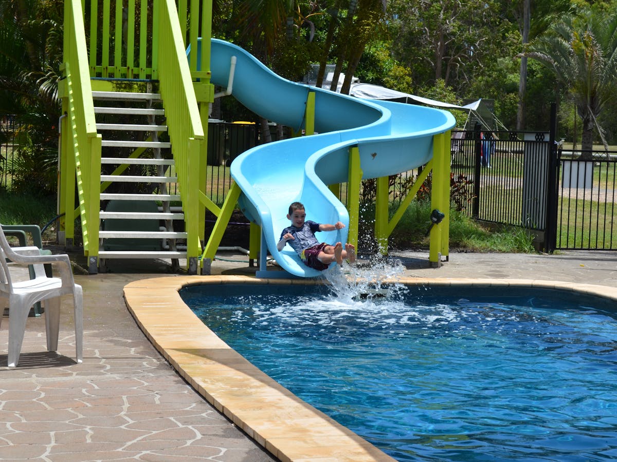 photo of boy sliding down wetslide into pool at Poona Palms Caravan Park