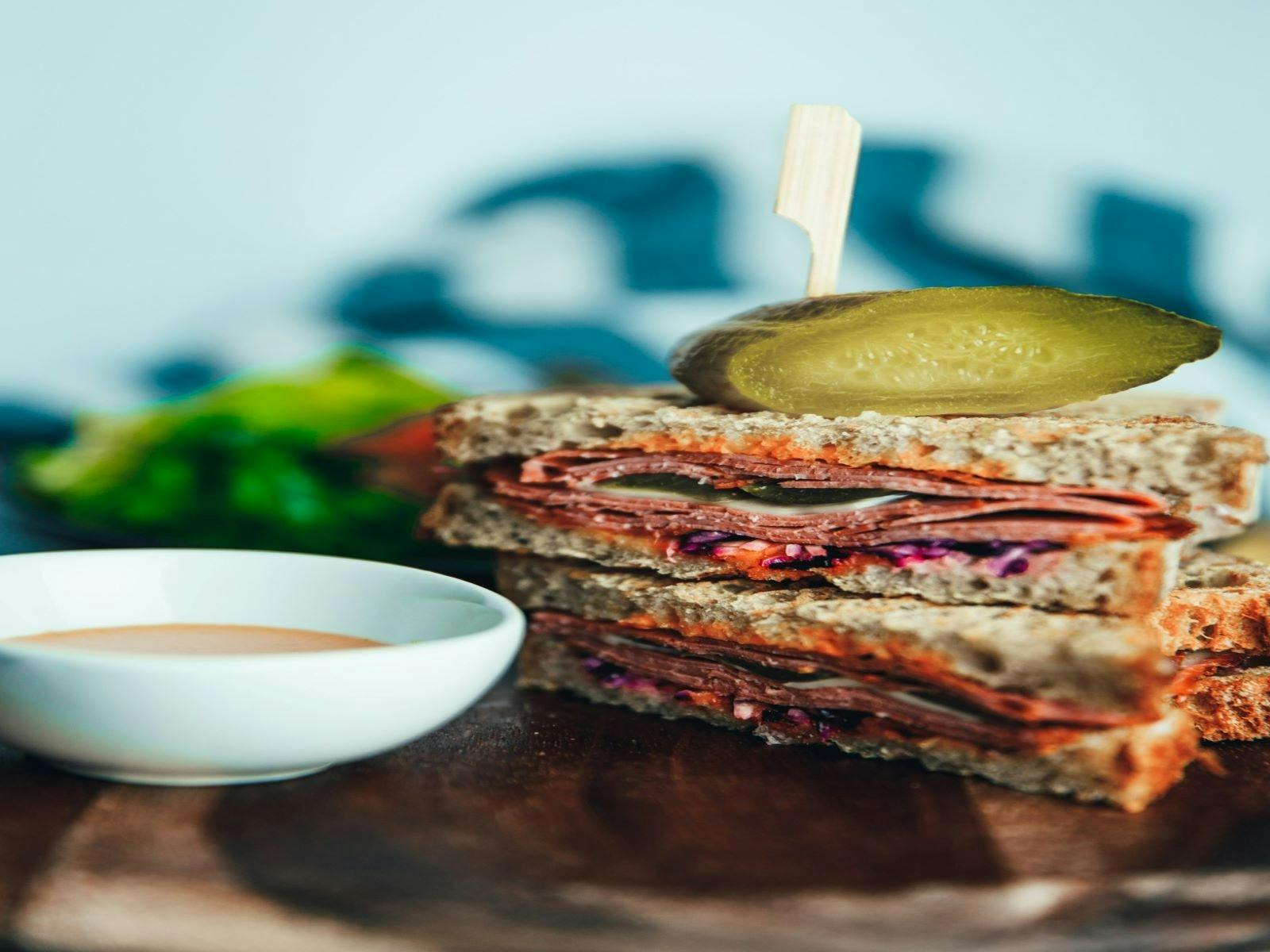 Picnic Society's Signature Sandwich with homemade pickles, shaved corn beef, bitey cheese and salad Picnic Society's Signature Sandwich with homemade pickles, shaved corn beef, bitey cheese and salad