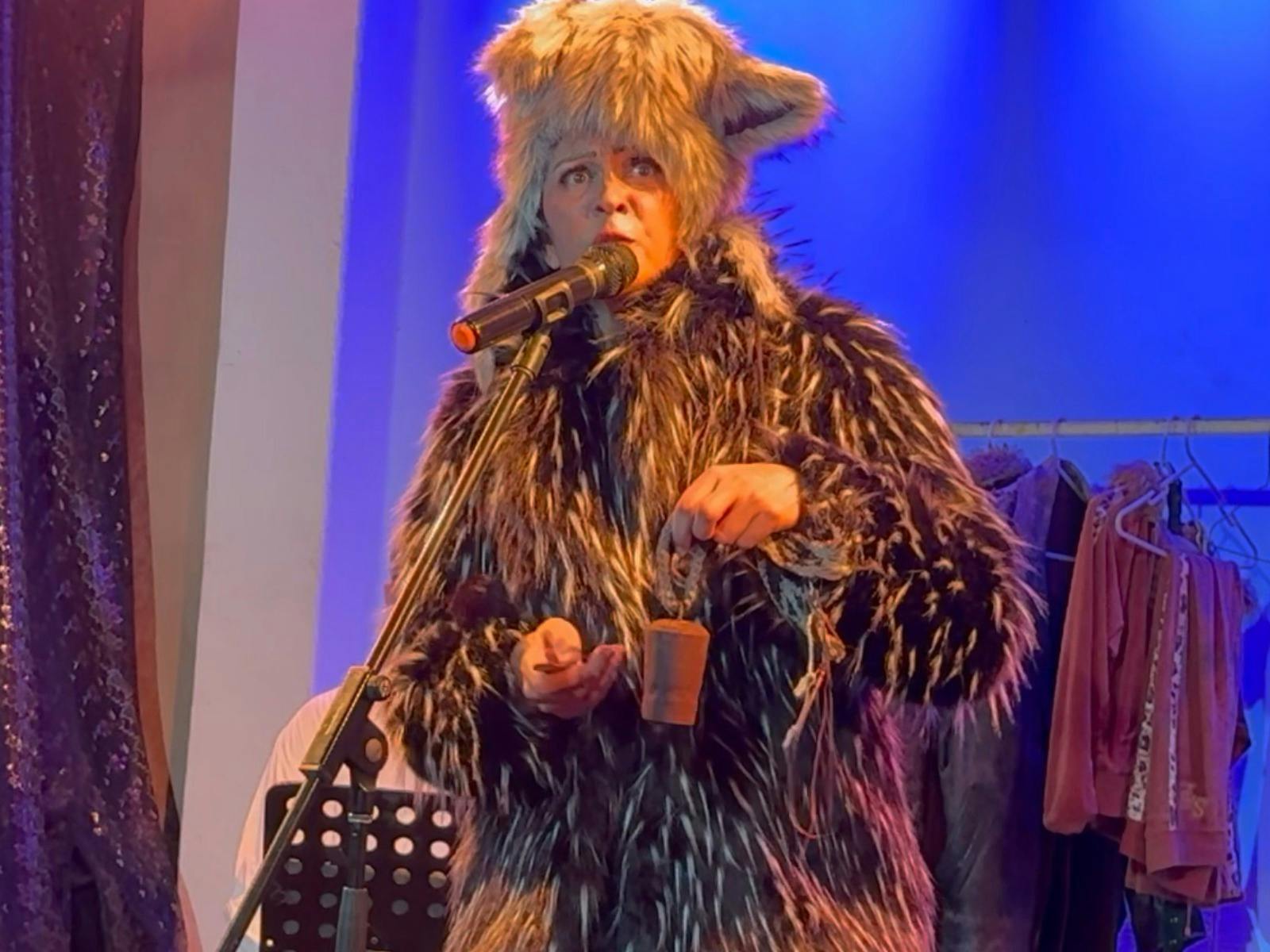 Woman in fur hat and coat with a cowbell