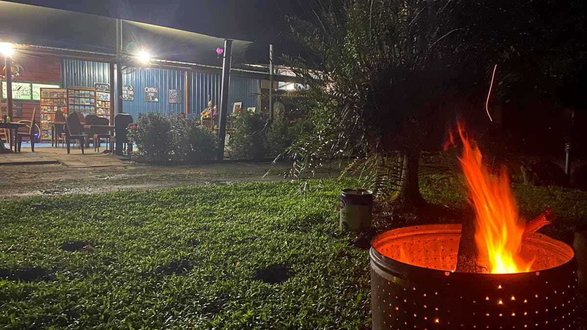 Communal Fire with flame and grass area with al fresco  restaurant seating area