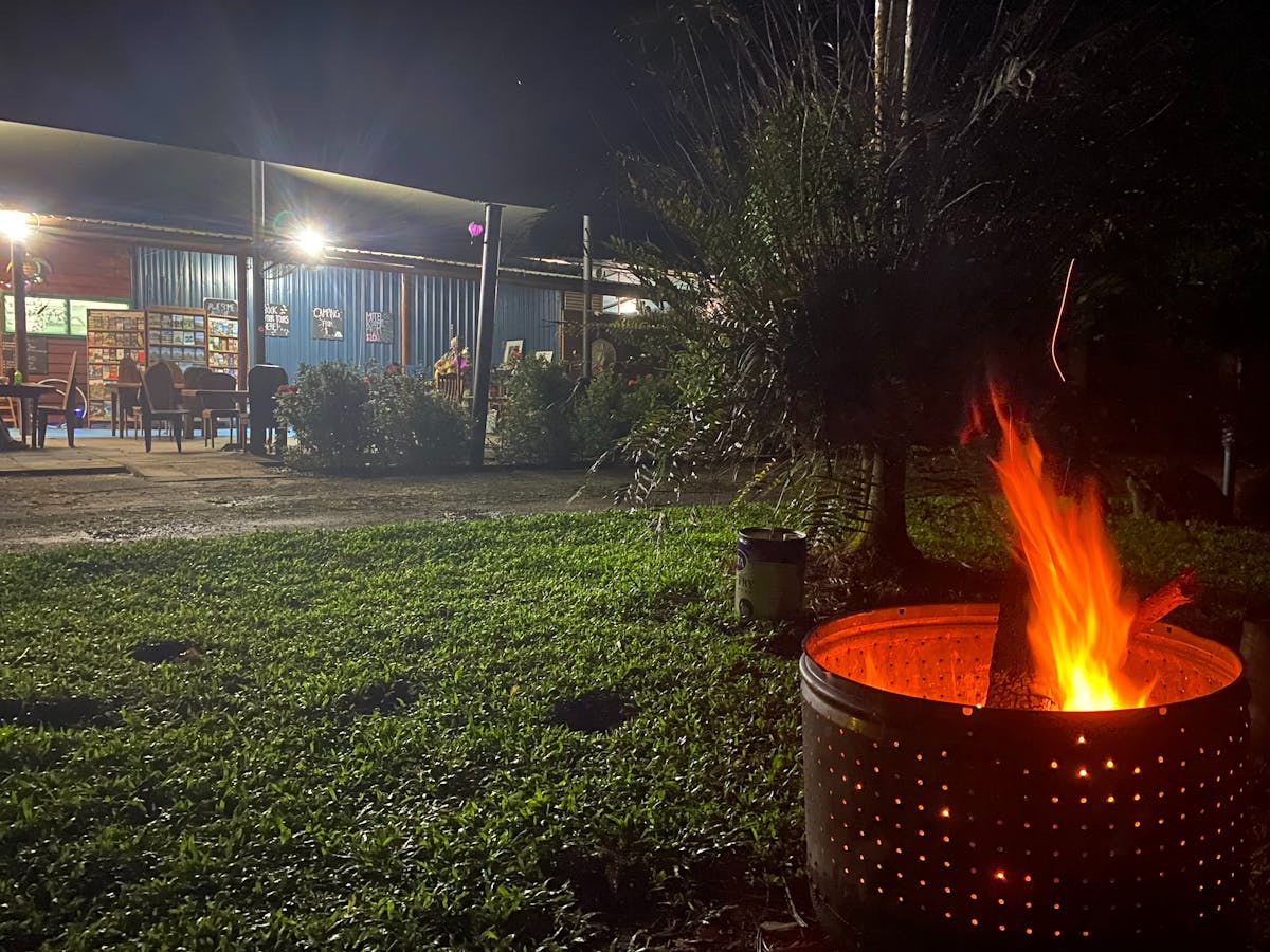 Communal Fire with flame and grass area with al fresco restaurant seating area