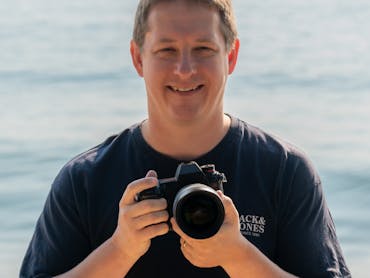Mark standing on the beach with his camera Mark standing on the beach with his camera
