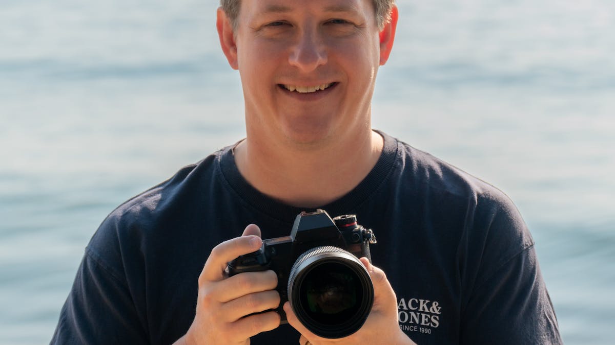 Mark standing on the beach with his camera