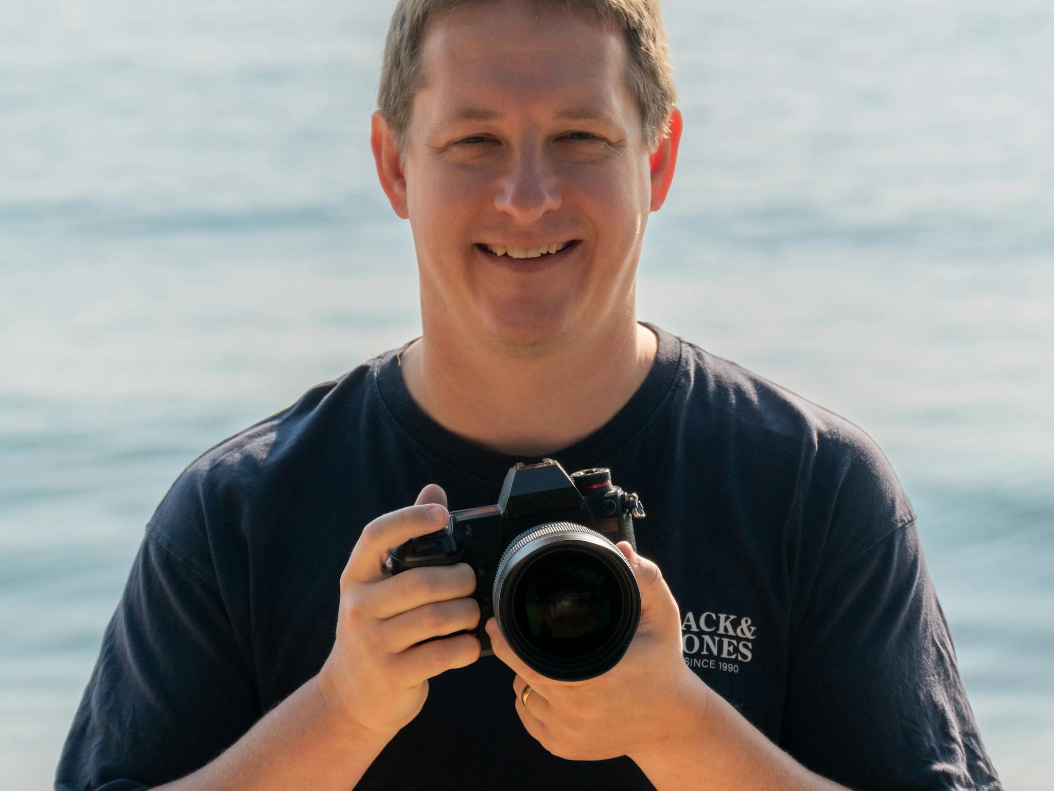 Mark standing on the beach with his camera Mark standing on the beach with his camera