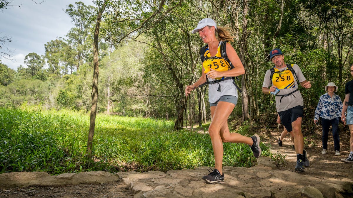 Two runners cross a stone bridge