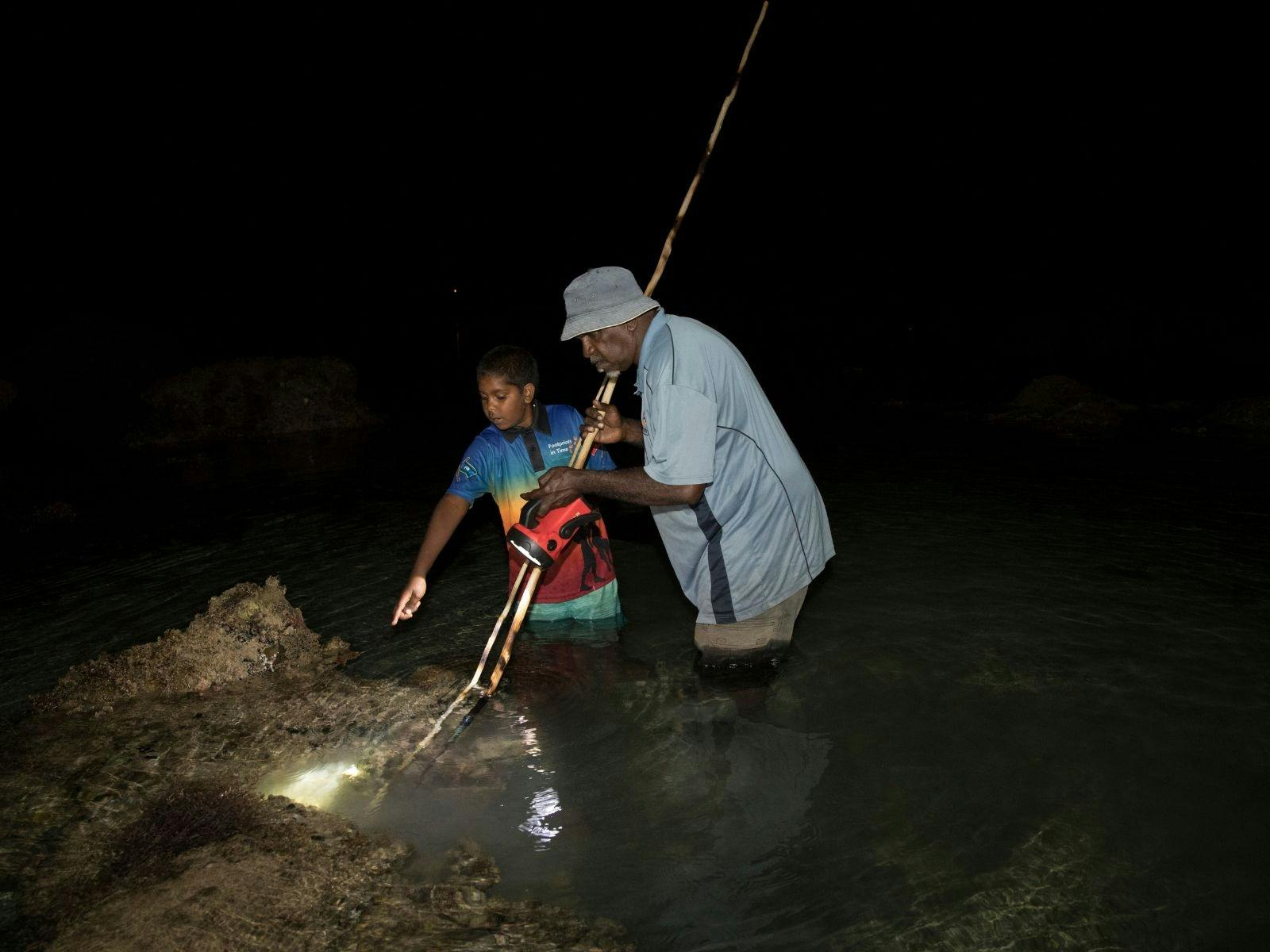 Bundy fishing with little boy with spear.