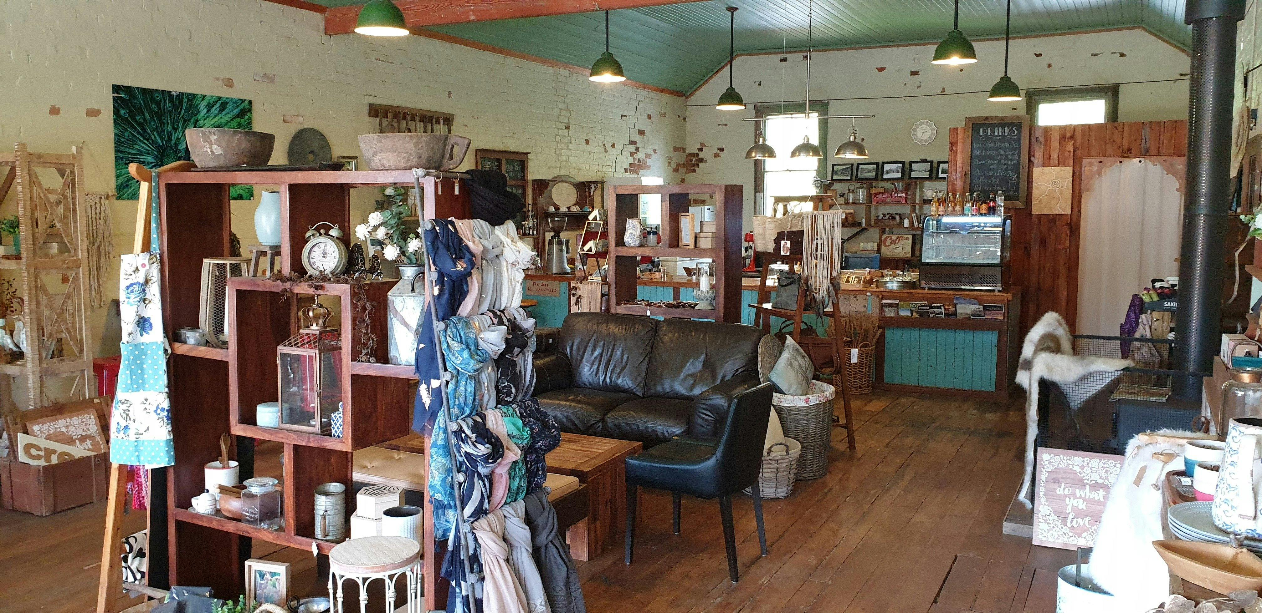 Inside shop with lounge, seating, shelves with giftware. You can see the charm of the old building.