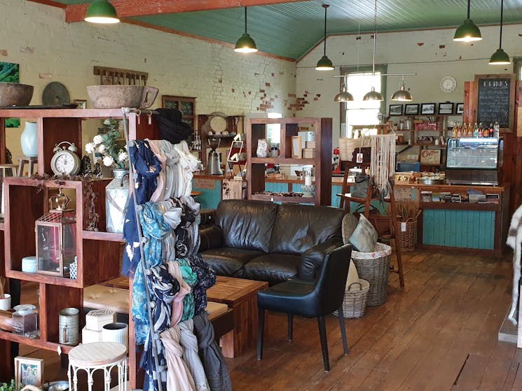 Inside shop with lounge, seating, shelves with giftware. You can see the charm of the old building.