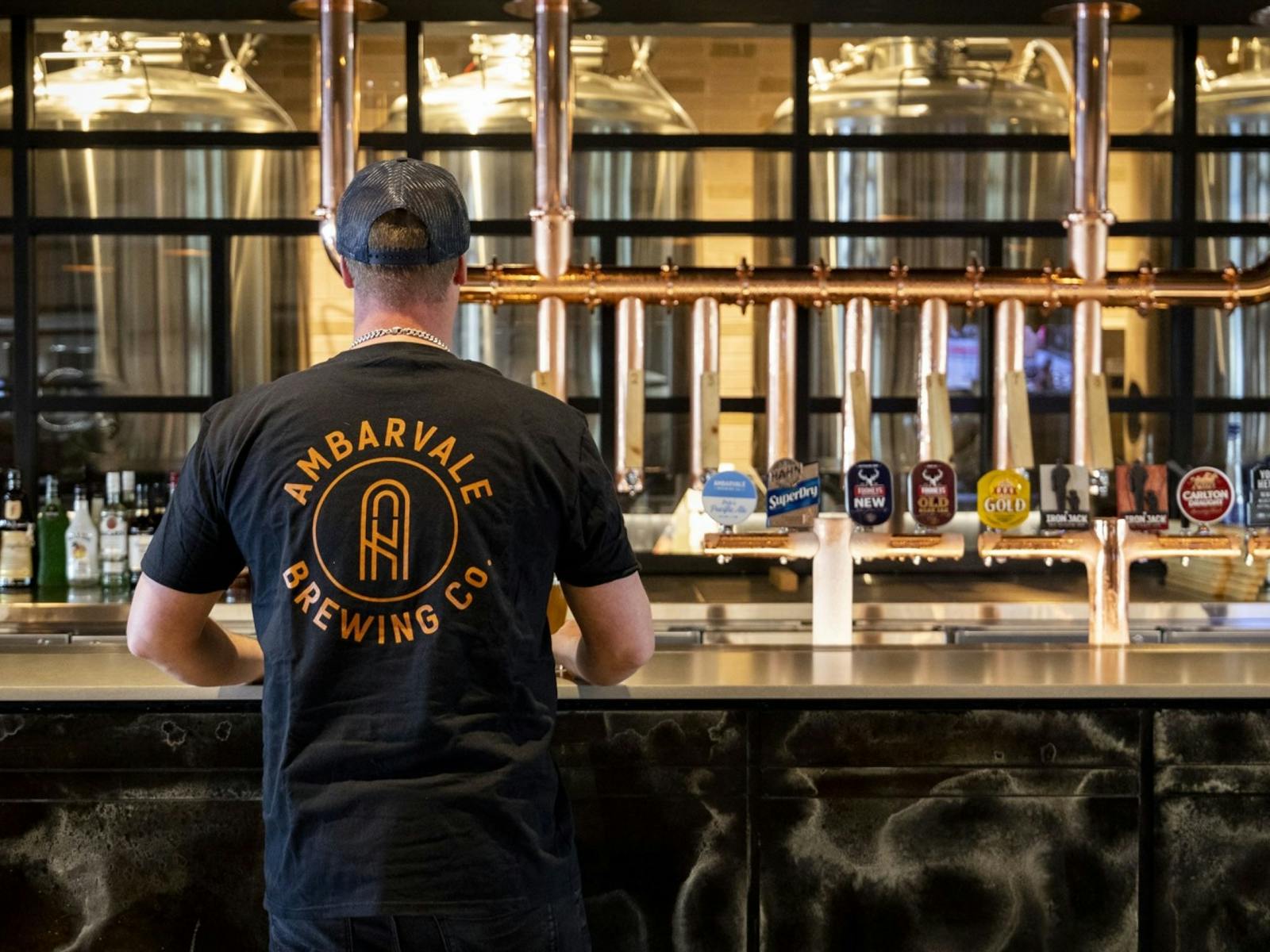 Bartender at Ambarvale Brewing Co wearing merchandise shirt