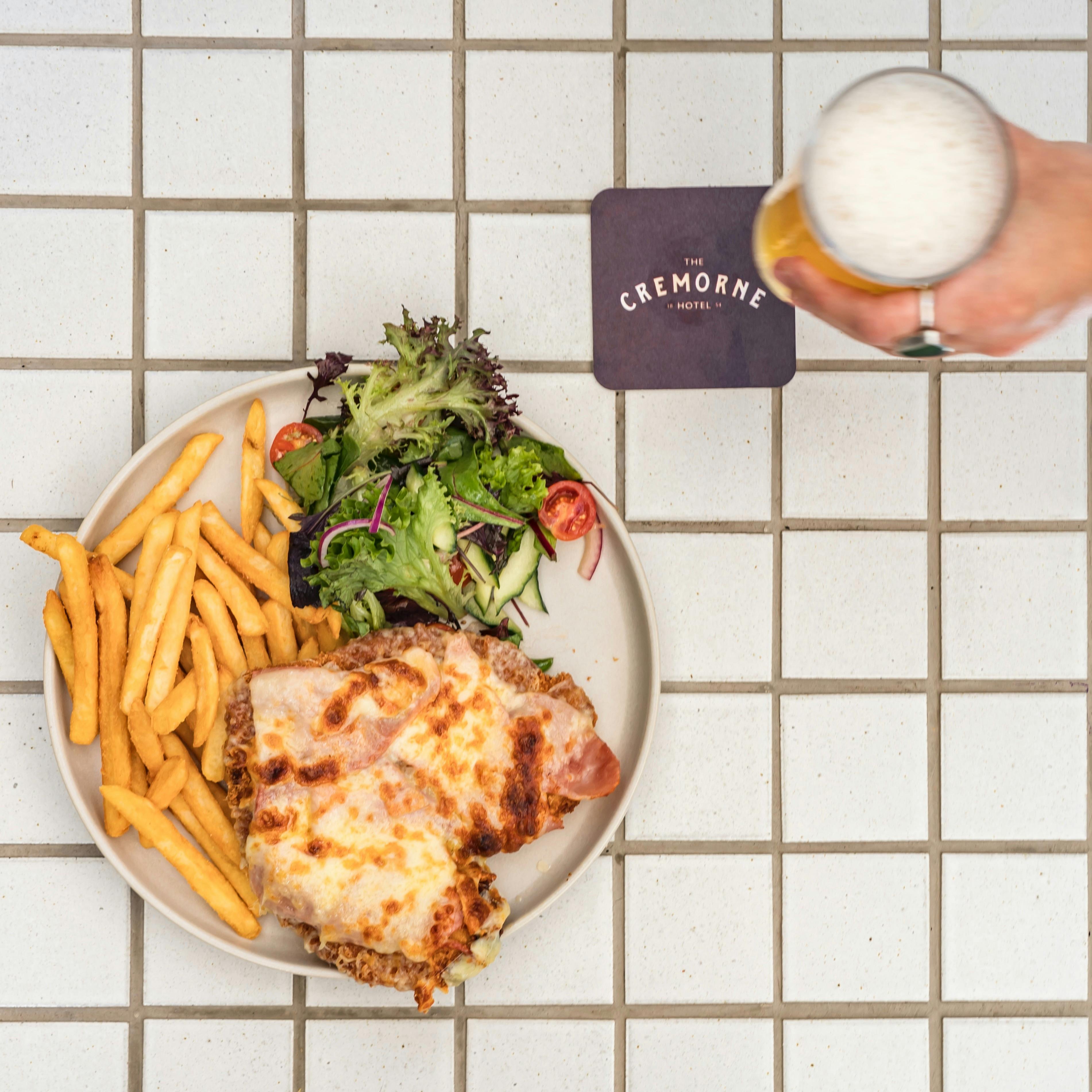Enjoy the Cremorne's signature chicken parmi, served with  chips and salad. And an icy cold beer.