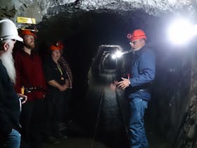 Mine Manager Geoff Anderson and a group of people standing in an underground tunnel on a tour.