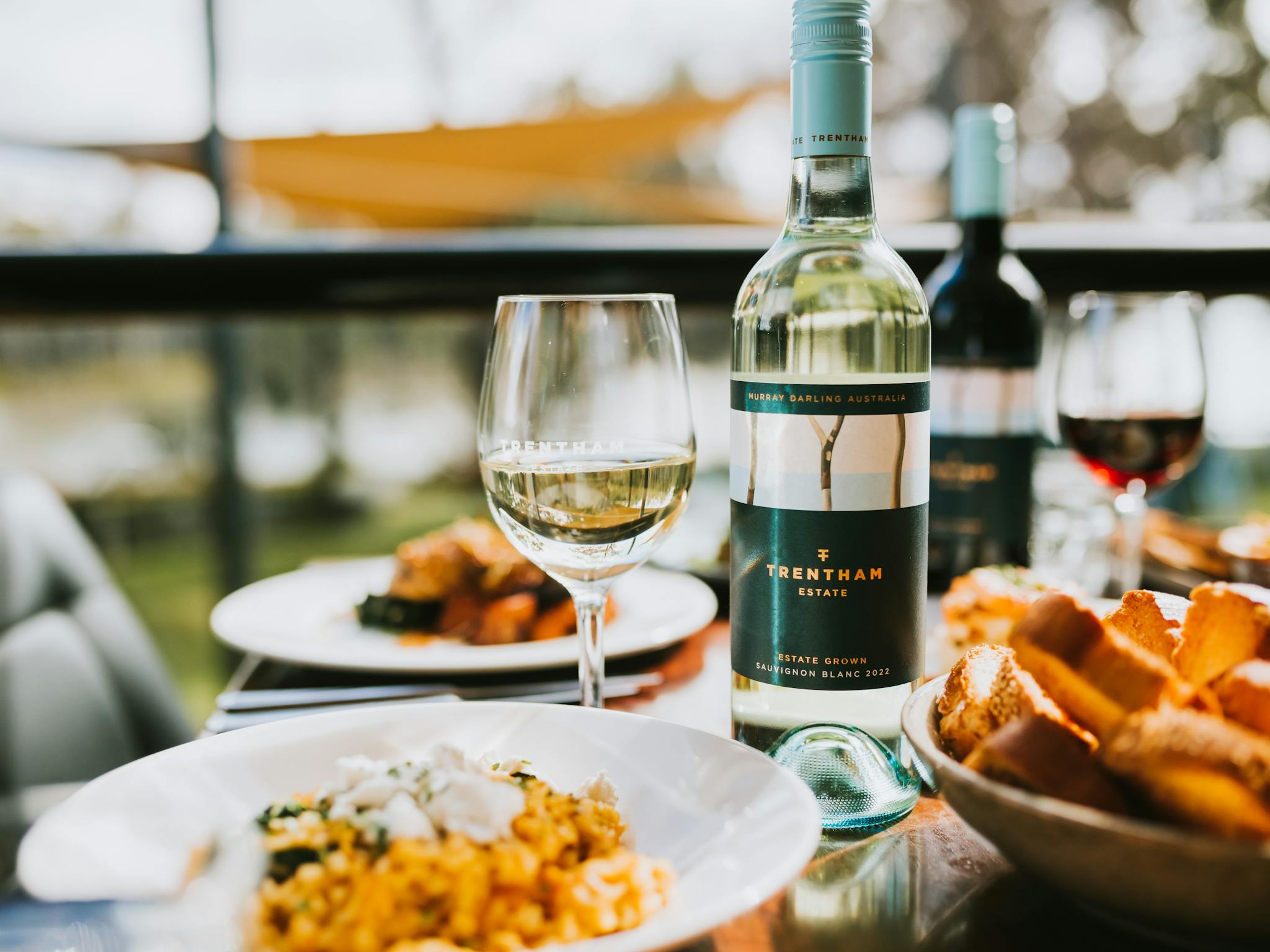 Table set with food and wine on the restaurant's balcony overlooking the river