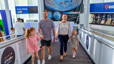 family of 4 walk up the Questacon ramp by the ticket desk