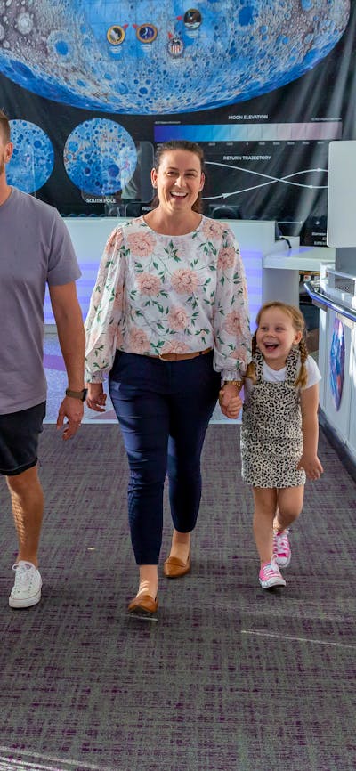 family of 4 walk up the Questacon ramp by the ticket desk