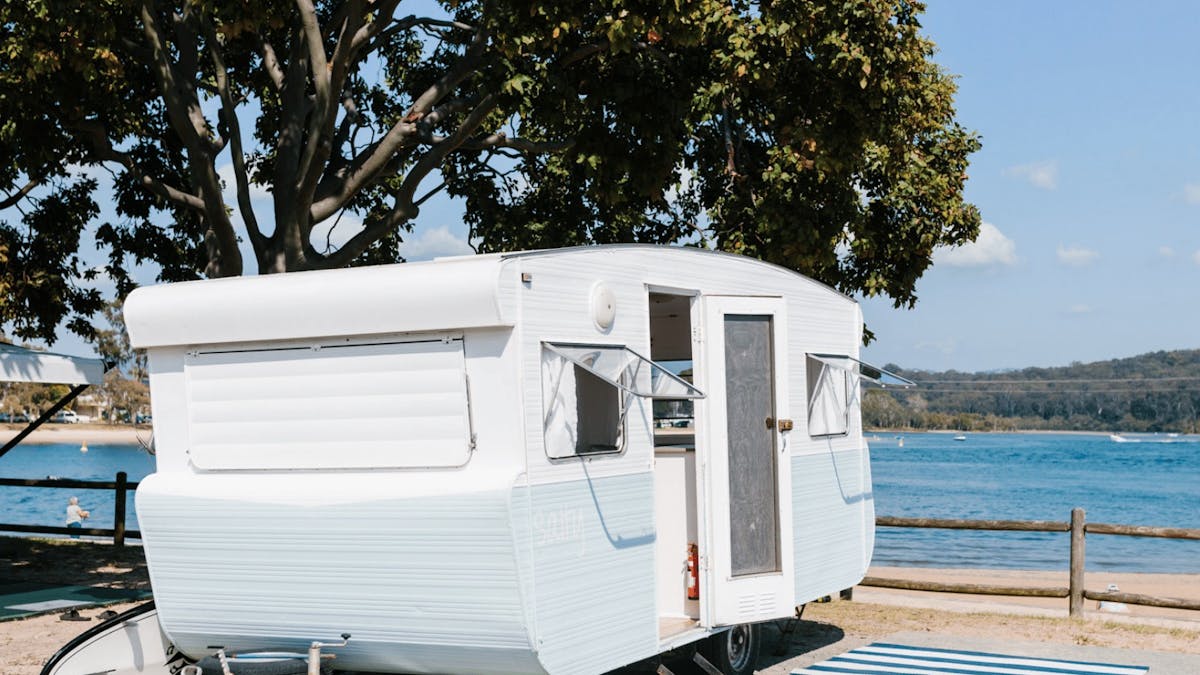 Cute and quirky vintage caravan in front of lake in Queensland