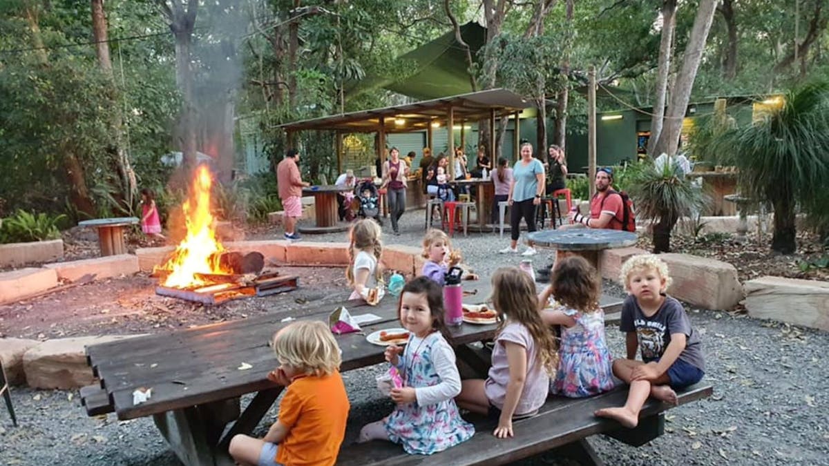 Kids sitting at a campsite on a bench