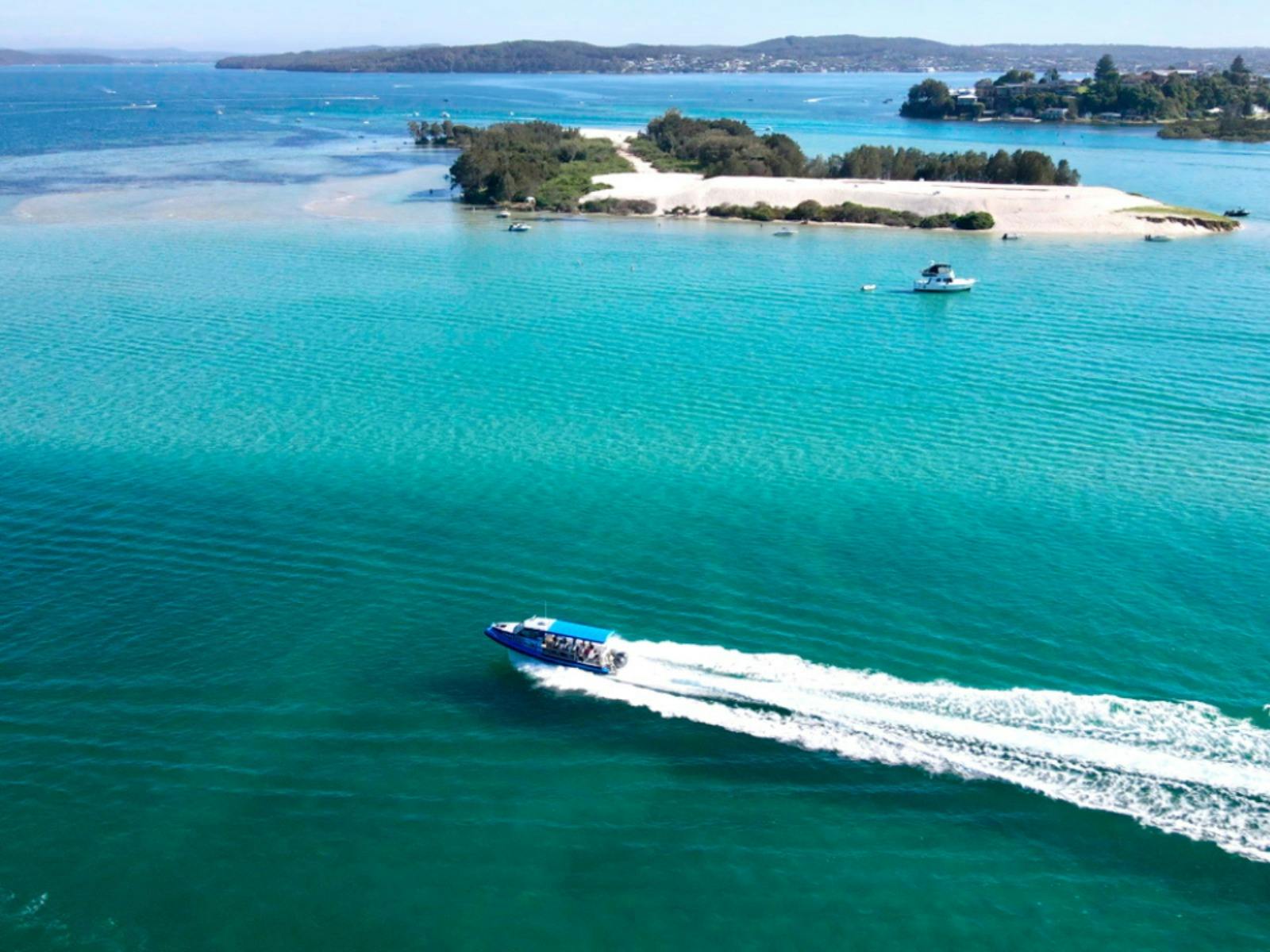 Boot gleitet von oben durch blaues Wasser