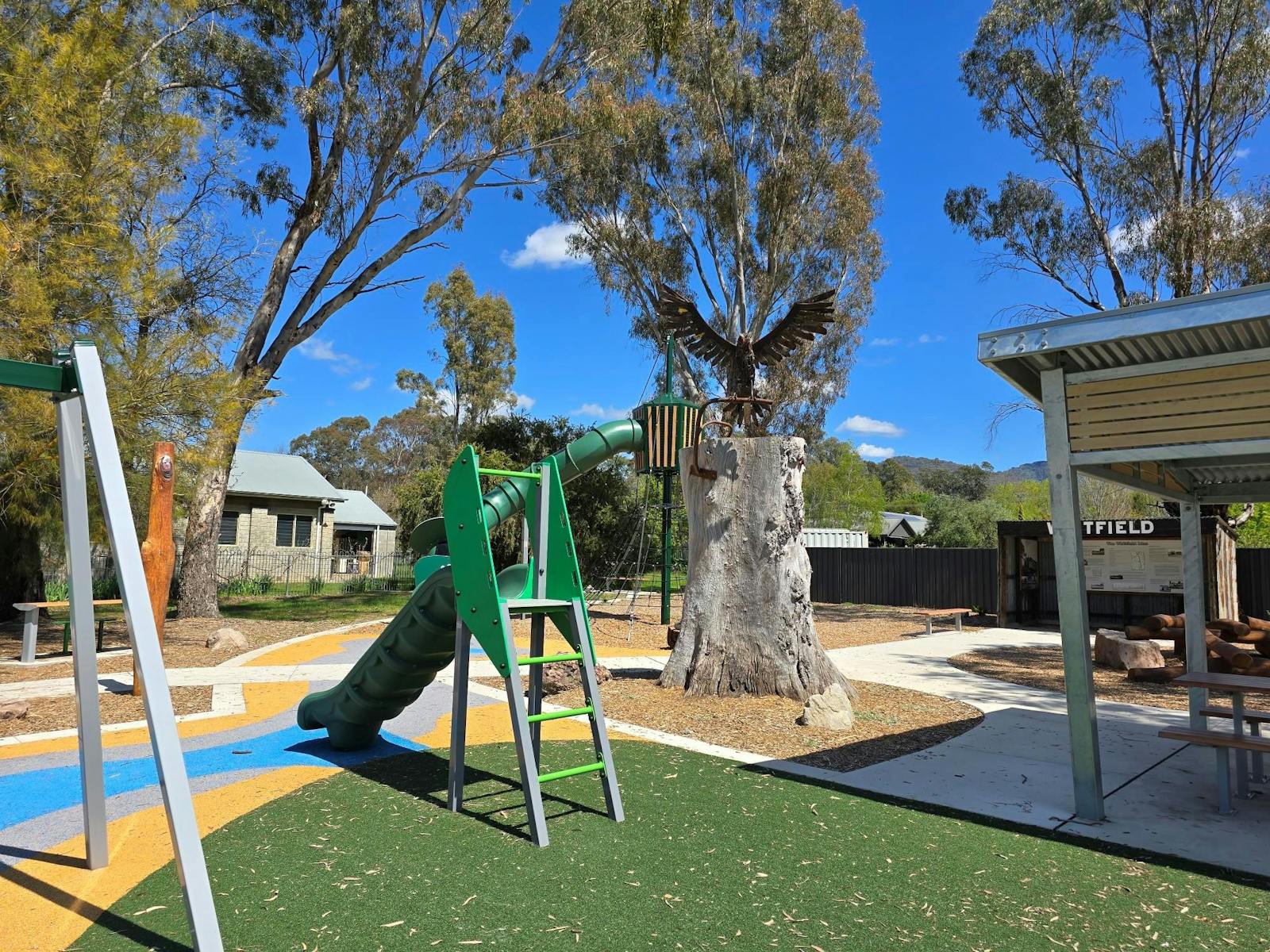 Small slide placed on a green surface with a wedge tailed eagle sculpture in the background