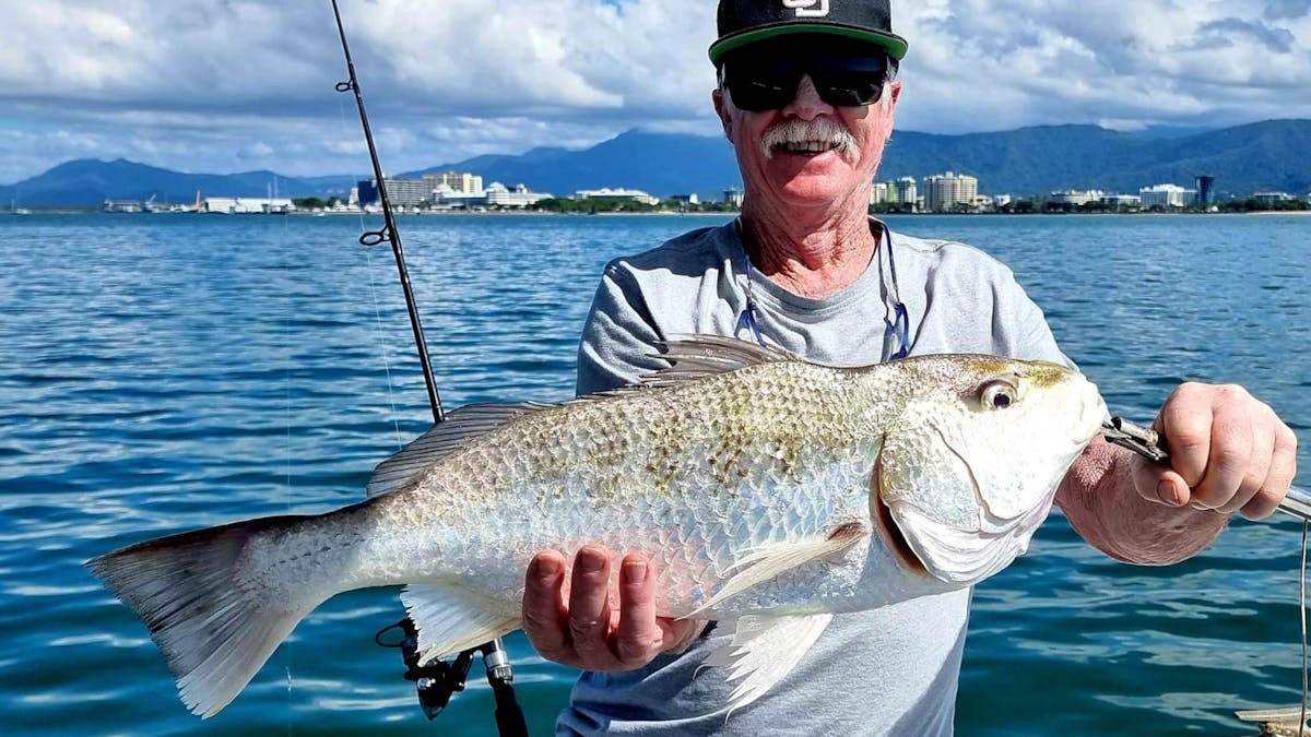 Man holding a big grunter fish with Gone Fishing Cairns on Trinity Inlet Man holding a big grunter fish with Gone Fishing Cairns on Trinity Inlet