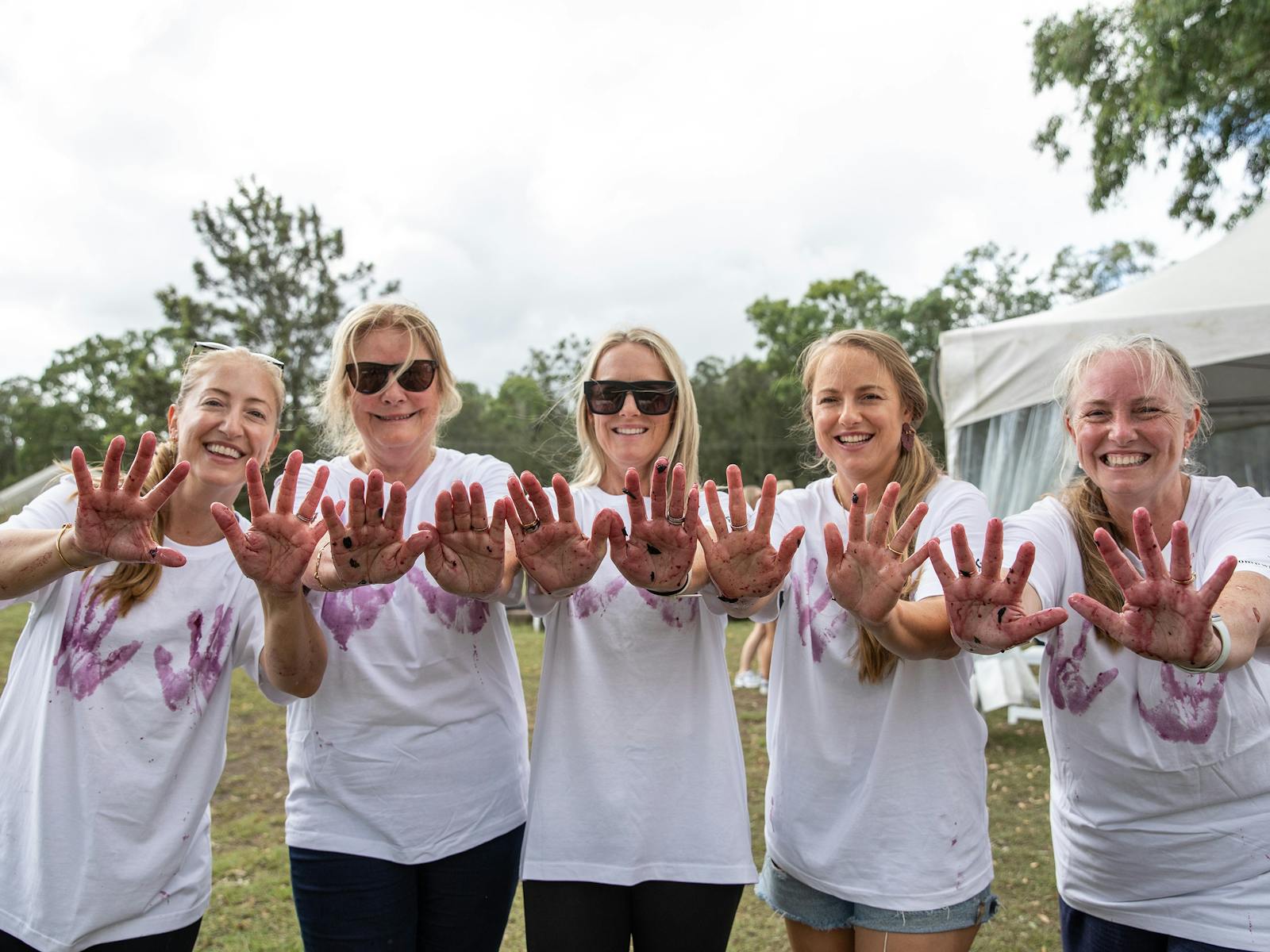 A group of women with grape juice hands