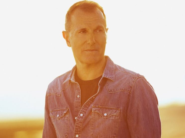 Close up of James Reyne standing outside looking to his left