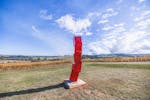 Kinetic Red Sculpture, situated in a picturesque vineyard.
