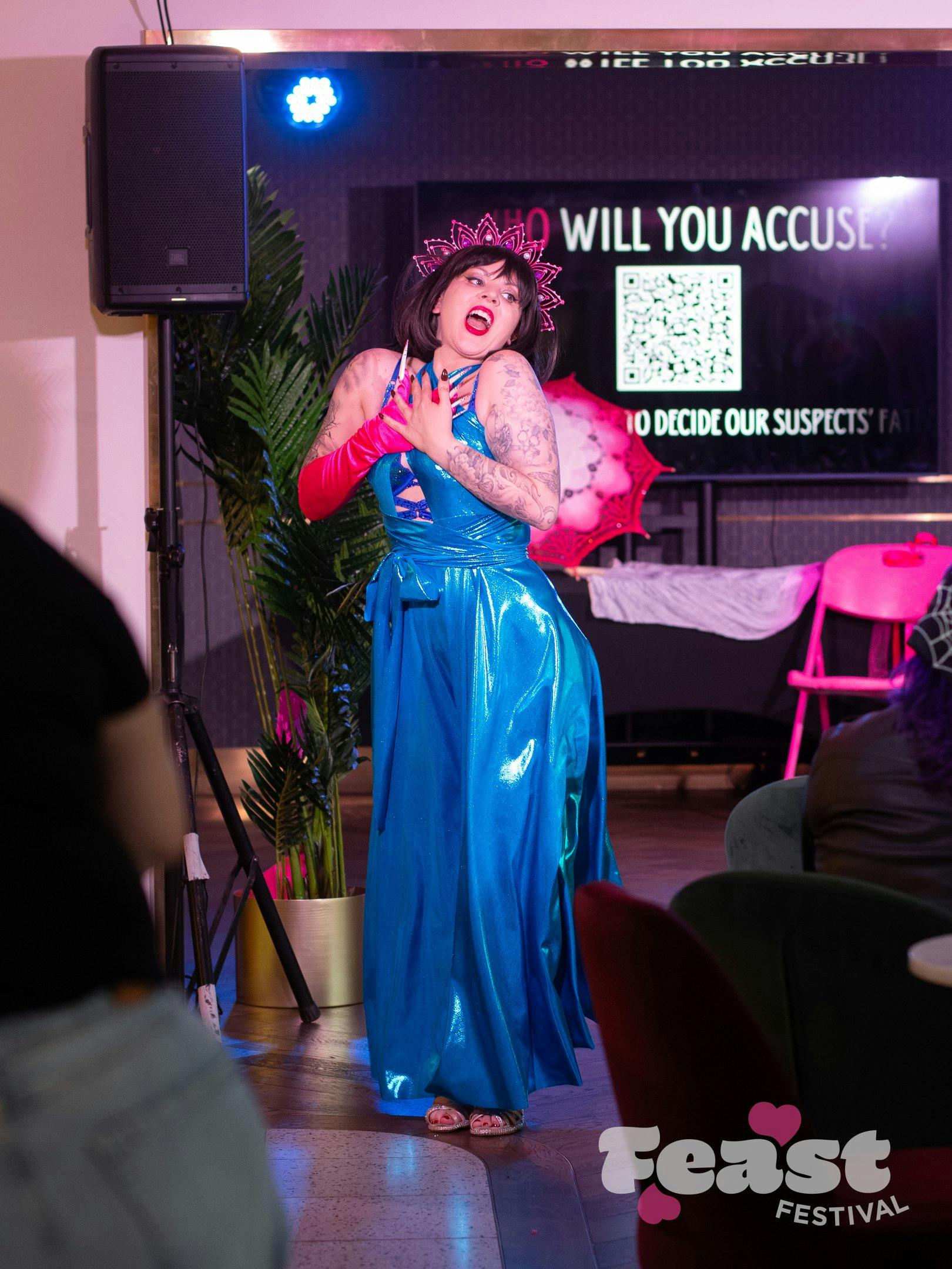 Performer singing in blue dress, pink accessories