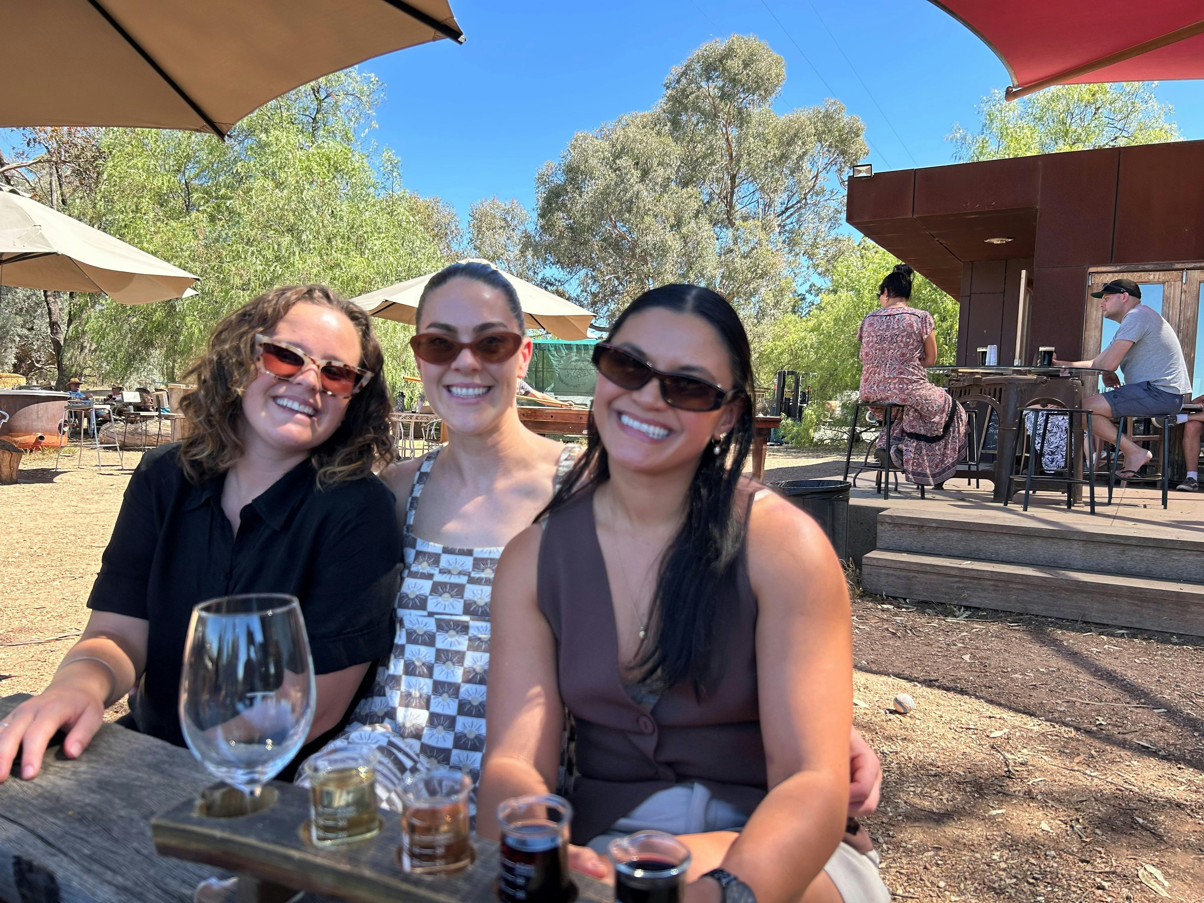 Three women smile at the camera