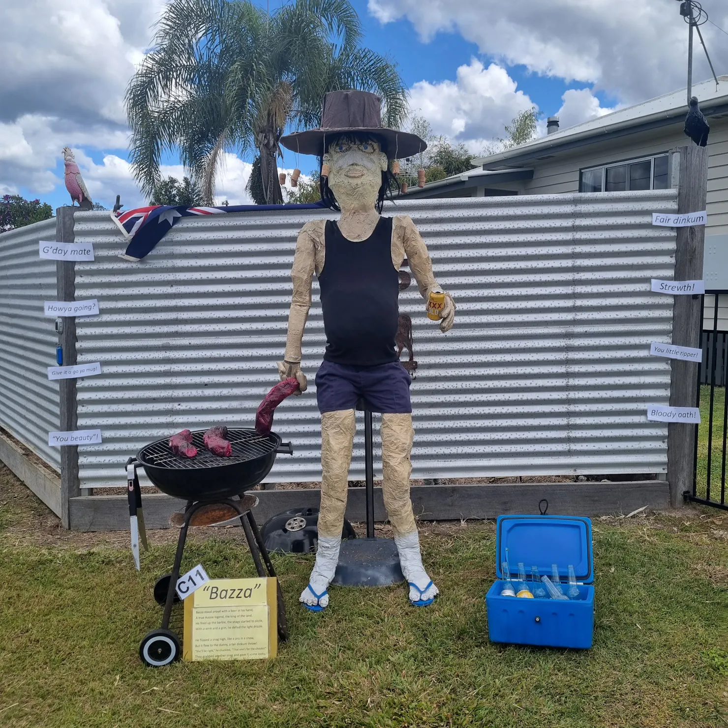 Scarecrow man cooking sausages on a barbecue.