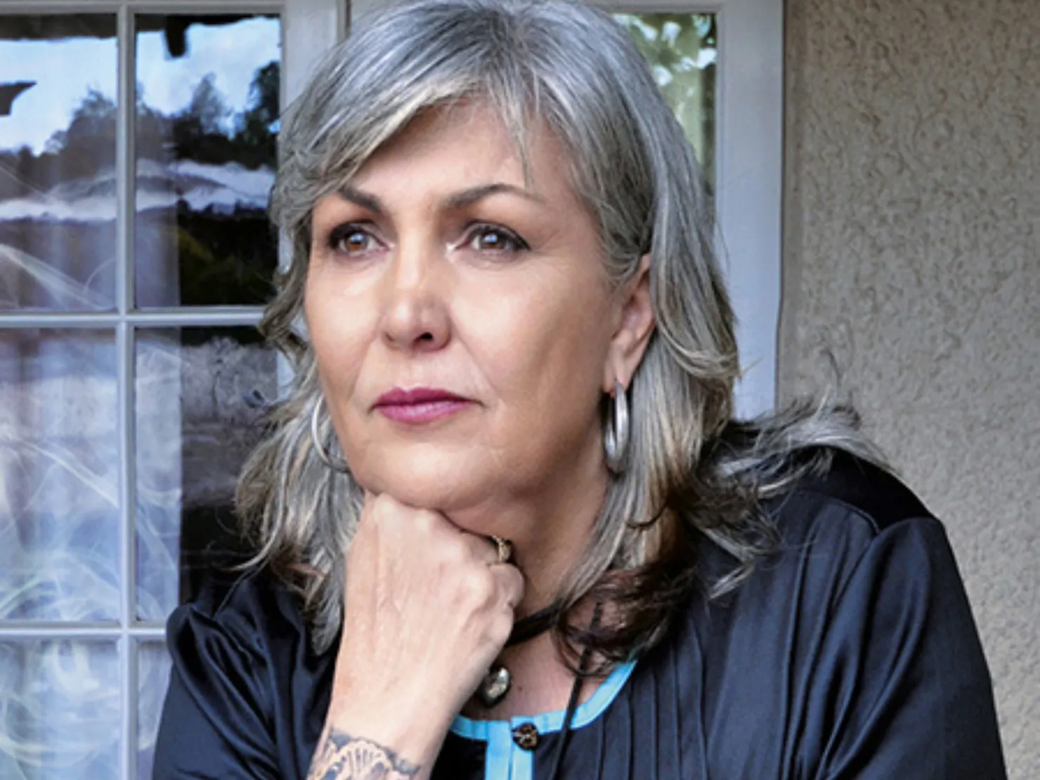 A middle aged lady with grey hair looking away.