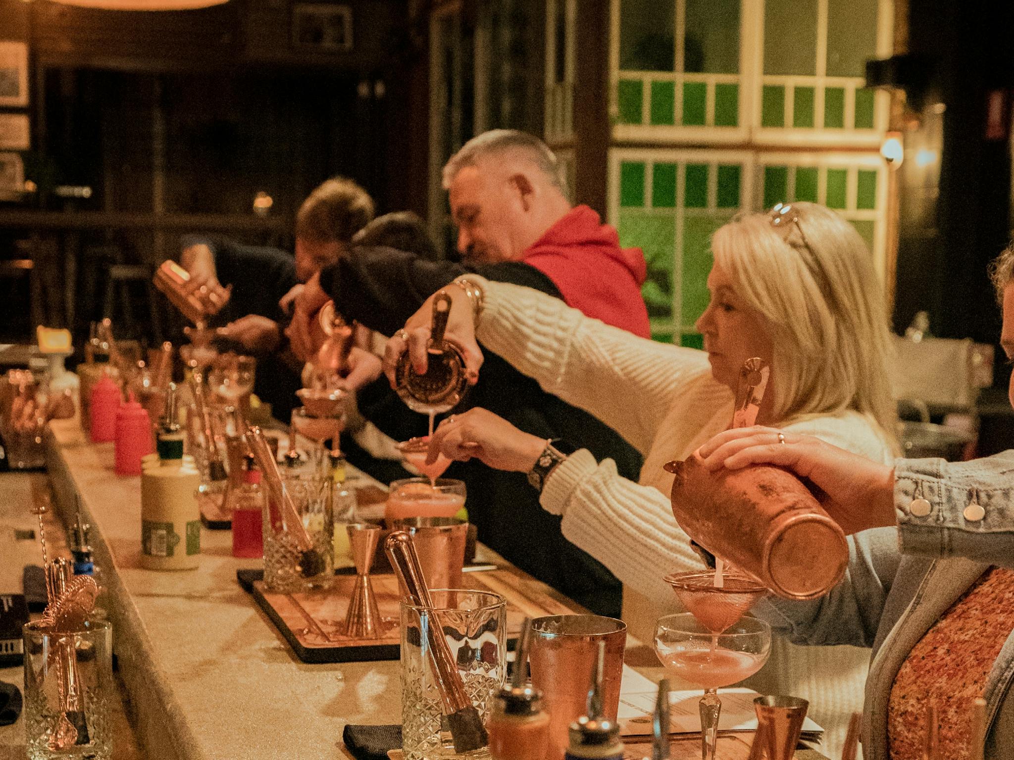 Guests using the barware to pour their own cocktails. Guests using the barware to pour their own cocktails.