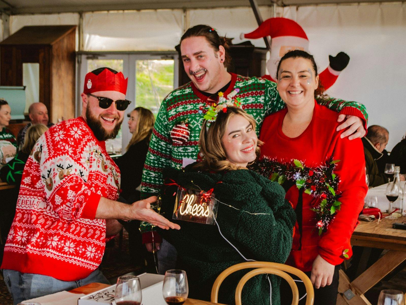 People wearing festive attire, posing for a photo