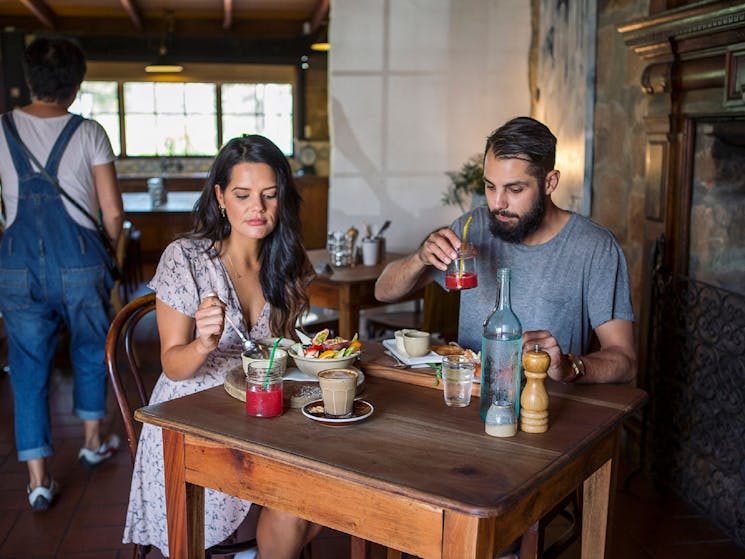 Couple enjoying a relaxed breakfast at Cafe Enzo, Pokolbin