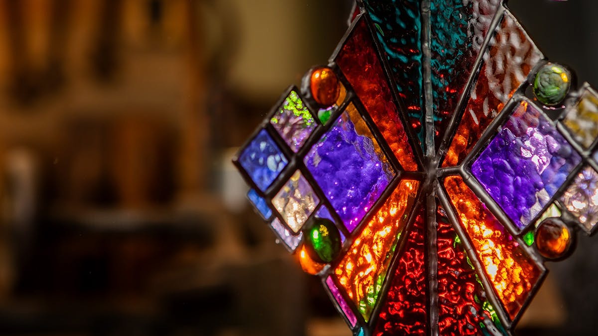 Glass art displayed in dark room with multi-coloured panels. Glass art displayed in dark room with multi-coloured panels.