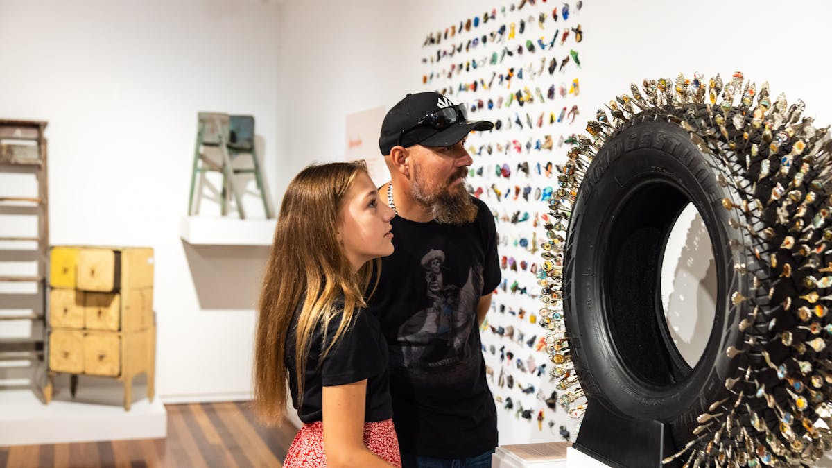 Lady and man looking at a wall-mounted exhibition item